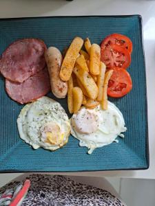 a plate of food with eggs sausage and french fries at Charis on Beaumont in Margate