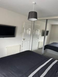 a bedroom with a bed and a flat screen tv at Townhead Road in Inverurie