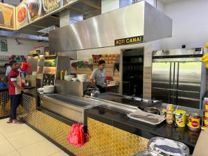 zwei Personen bereiten in einer Restaurantküche Essen zu in der Unterkunft KL City Nue Suites Entire Condo 2R2B 3 plus 1 guests in Kuala Lumpur