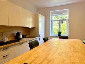 una cocina con una gran mesa de madera y una ventana en Charmant quadruplex au cœur de la Vallée, en La Broque 22 fotos más