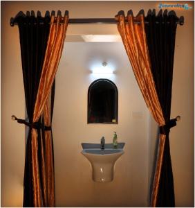 a bathroom with a sink and a mirror at Navaratna Holiday Homestay in Vagamon
