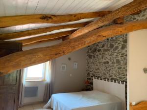 a bedroom with a bed and a stone wall at Holiday Home Saint-Beauzire near Pauillac Castle in Saint-Beauzire