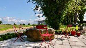 un gruppo di sedie rosse sedute accanto a una roccia di The Tin Shed a Tara