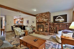 a living room with a brick fireplace and a living room at 93 Glazebrook Rd, Unit E2 - Ski Condo - Summer Pool - Close to Mountain! in Killington