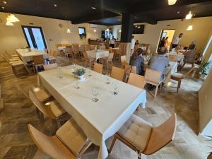 a dining room with white tables and chairs at Pensiunea 82 in Nădlac