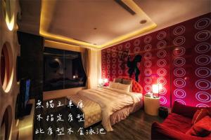 a bedroom with red walls and a bed and a couch at Bali Motel - Zhongli in Zhongli