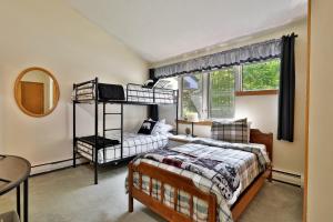a bedroom with two bunk beds and a window at Woods Resort and Spa A7 - Cozy 2-Bedroom Condo with Skiing, Tennis, Spa, Hot Tub and Pool Access in Killington +40 photos