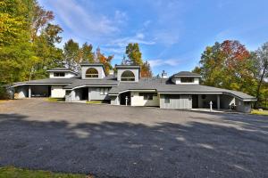 a large house with a driveway in front of it at Woods Resort and Spa A7 - Cozy 2-Bedroom Condo with Skiing, Tennis, Spa, Hot Tub and Pool Access in Killington