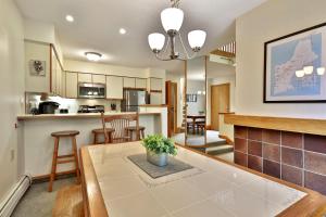 a kitchen and living room with a table and chairs at Woods Resort and Spa A7 - Cozy 2-Bedroom Condo with Skiing, Tennis, Spa, Hot Tub and Pool Access in Killington