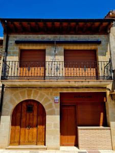 a building with two garage doors and a balcony at Casas Rurales Peña Flor 8 in Carcastillo