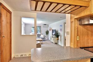 a kitchen with a counter and a living room at The Mendon Cottage - Charming Vermont Home Close to Pico, Ski Rental Deals! in Mendon