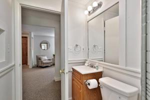 a bathroom with a toilet and a sink and a mirror at The Mendon Cottage - Charming Vermont Home Close to Pico, Ski Rental Deals! in Mendon +23 photos