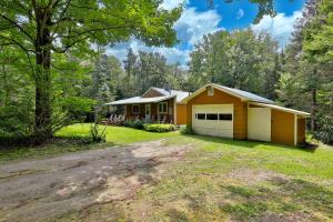 a yellow house with a garage in the woods at The Mendon Cottage - Charming Vermont Home Close to Pico, Ski Rental Deals! in Mendon