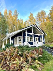 a blue and white house in the woods at Blueberry Villa at Saimaa Lakeside in Taipalsaari