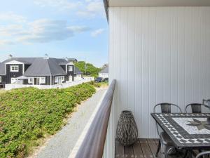ein Balkon mit Tisch und Stühlen und ein Haus in der Unterkunft 4 person holiday home in Ringkøbing-By Traum in Ringkøbing