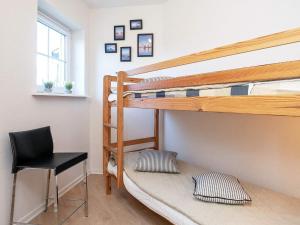 a bedroom with a bunk bed with a desk and a chair at 5 person holiday home on a holiday park in Bogense in Bogense