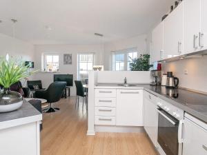 a kitchen with white cabinets and a dining room at 5 person holiday home on a holiday park in Bogense in Bogense
