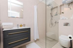 un baño con lavabo y ducha en Apartments Sanja, en Tribunj 33 fotos más