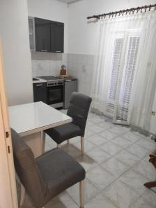 a kitchen with a table and two chairs and a stove at Apartment Tenara in Vis +9 photos