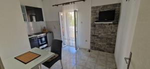 a kitchen with a stove and a table and a television at Apartment Tenara in Vis