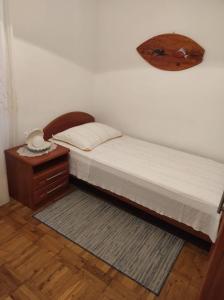 a small bedroom with a bed and a night stand at Apartment Tenara in Vis