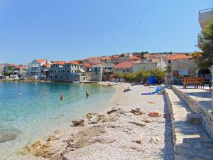 a beach with a group of people in the water at Apartment Fran in Postira