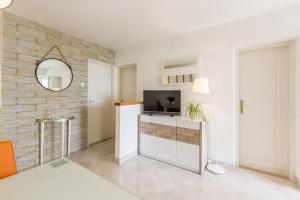 a living room with a tv and a wall at Apartments Matea in Bol