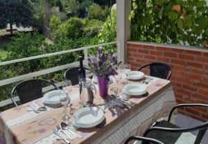 a table with plates and glasses and a vase of flowers at Apartments Mar in Sutivan