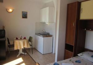 małą kuchnię ze stołem i zlewem w obiekcie Apartments and Room Dar w Hvarze