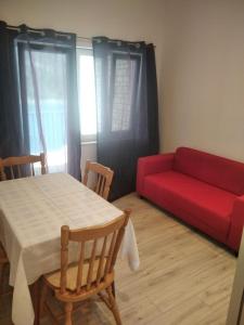 a living room with a red couch and a table at Apartments Ivan in Vinišće