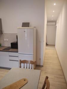a kitchen with a white refrigerator and a table and chairs at Apartments Ivan in Vinišće