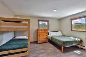 a bedroom with two bunk beds and a window at West Park Chalet - Large Vermont Ski Home - Great for Groups! Hot tub, games, ski rental ticket deals! in Killington