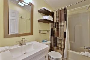 a bathroom with a sink and a toilet and a mirror at The Bomoseen Bungalow - Vermont Lake House Close to Ski Resorts! Private dock, ski rental ticket deals in Bomoseen +27 photos