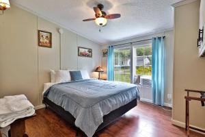 a bedroom with a bed and a ceiling fan at The Bomoseen Bungalow - Vermont Lake House Close to Ski Resorts! Private dock, ski rental ticket deals in Bomoseen
