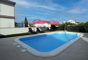 a swimming pool in a yard next to a house at Apartment Mihovilovic in Slatine