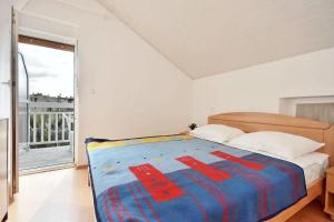 a bedroom with a bed and a large window at Apartment Toma in Omiš