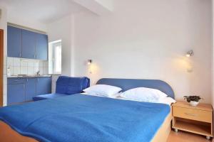 a bedroom with a blue bed and a blue chair at Apartment Toma in Omiš