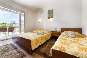 ein Schlafzimmer mit zwei Betten und einem großen Fenster in der Unterkunft Apartment Goge in Vodice