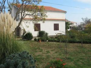 a white house with a garden in front of it at Apartment Dita in Nin