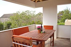 a wooden table and chairs on a balcony at Apartment Dita in Nin