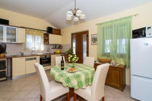 cocina con mesa con sillas y nevera blanca en Apartment Mirja, en Nečujam 20 fotos más