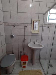 a bathroom with a sink and a toilet and a mirror at Pousada Casa da Cintia in Diamantina