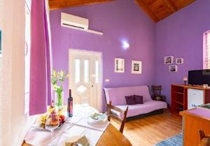 a purple living room with a table and a couch at Apartments Zeljko in Račišće