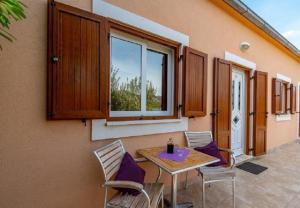a patio with a table and chairs and a window at Apartments Zeljko in Račišće