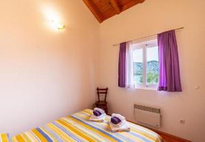 a bedroom with a bed and a window with purple curtains at Apartments Zeljko in Račišće