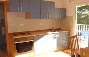 a kitchen with gray cabinets and a sink and a stove at Apartments Dijana in Sveta Nedelja +7 photos