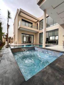 a house with a swimming pool in front of it at Villa Kenza piscine et jacuzzi chauffée in Marrakech