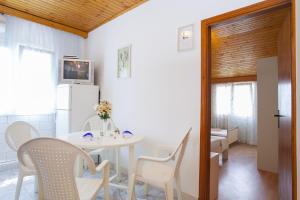 a kitchen and dining room with a table and chairs at Apartments Ante in Smokvica +19 photos
