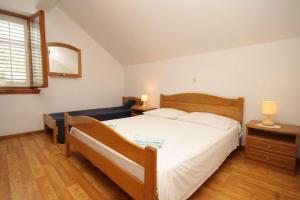 a bedroom with a large white bed and a window at Apartment Milan in Lastovo