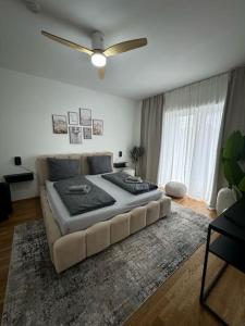 - un grand lit dans le salon doté d'un ventilateur de plafond dans l'établissement Sonnige Wohnung mit Balkon im Herzen von Bayreuth, à Bayreuth